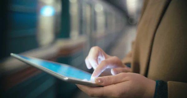 Woman using tablet PC by the leaving train in subway — Stock Photo, Image