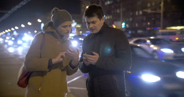 Young people using cells and talking in the street — Stock Photo, Image