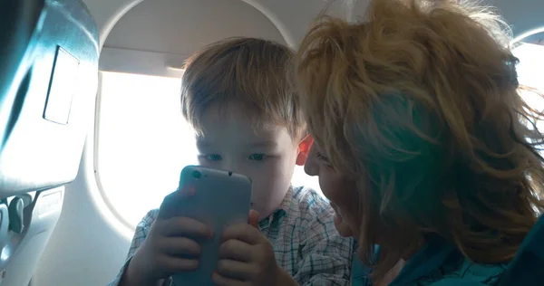 Grand-mère et petit-fils avec cellule dans l'avion — Photo