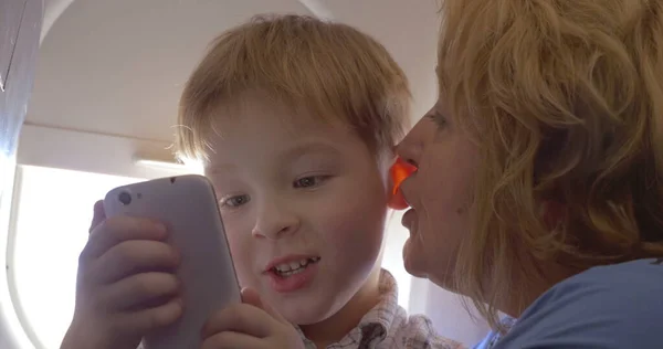 Grand-mère parlant à son petit-fils dans l'avion — Photo