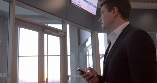 Zakenman chatten aan de telefoon op de luchthaven — Stockfoto