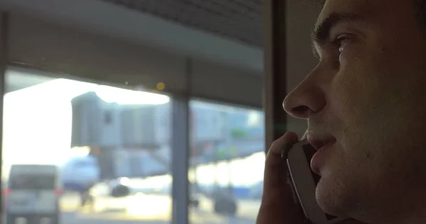 Мужчина разговаривает по телефону в аэропорту — стоковое фото