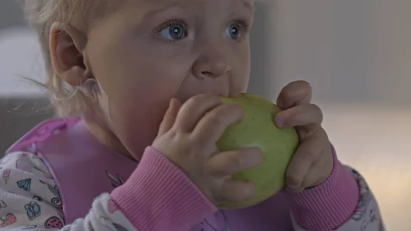 Baby meisje met een snack met appel — Stockfoto