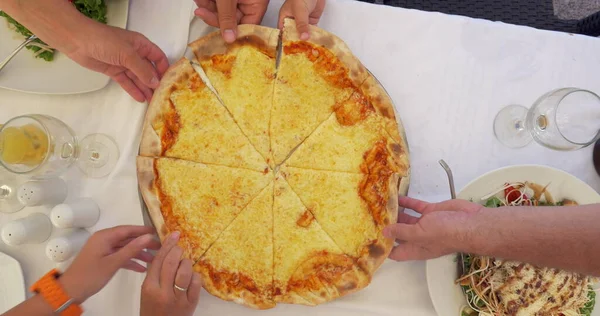 People taking slices of cheese pizza served in cafe — Stock Photo, Image