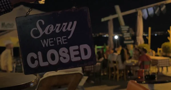 Вывеска "Магазин закрыт" открывается ночью на фоне пляжного кафе Салоники, Греция — стоковое фото