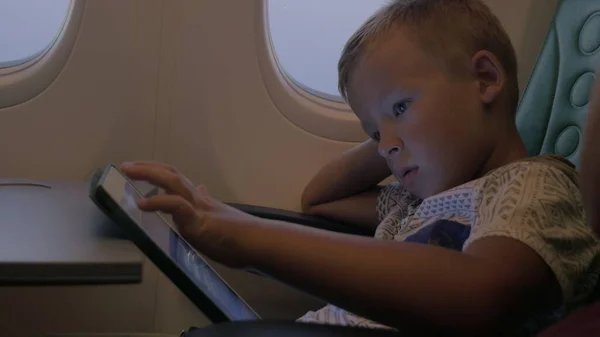 Niño usando almohadilla táctil durante el vuelo —  Fotos de Stock