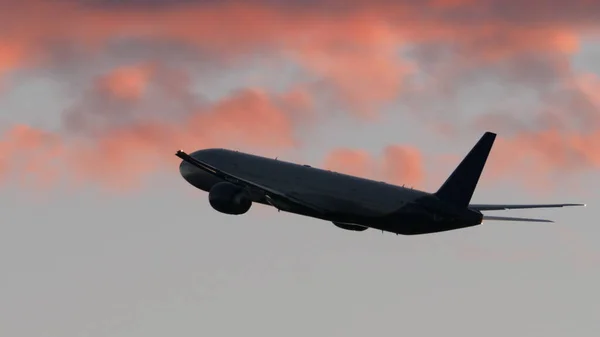 Avión volando en cielo nublado por la noche — Foto de Stock