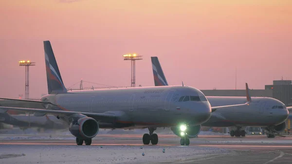 Zaparkowałem i kołowania samolotów na lotnisku Sheremetyevo w Moskwie. Widok zimowy wieczorem — Zdjęcie stockowe