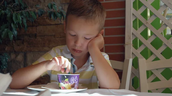 Kid eating chocolate ice cream dessert in summer cafe — Stock Photo, Image