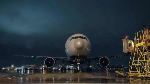 Vista sulla cabina di pilotaggio e sui motori dell'aereo di linea parcheggiato in aeroporto di notte — Foto Stock