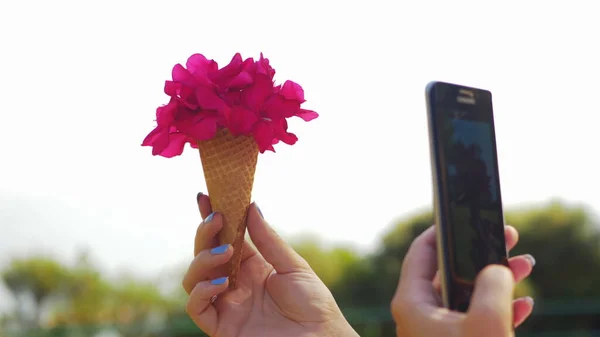 Mulher com móvel tirar fotos de cone buquê de flores — Fotografia de Stock