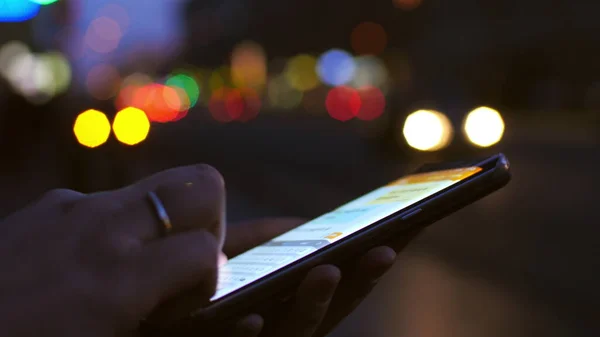 Dans la rue de nuit une fille travaillant sur le téléphone mobile — Photo