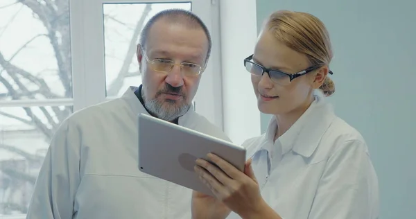 Dois médicos com conversa profissional usando touch pad — Fotografia de Stock