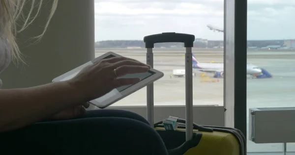 Frau wartet mit Tablet-PC auf den Flug — Stockfoto