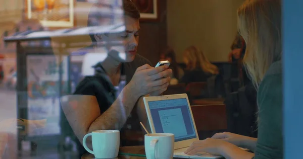 Young people with smart phone and laptop in cafe — Stock Photo, Image