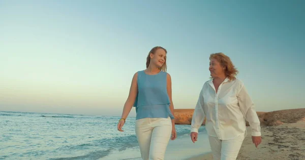 Madre e figlia che camminano vicino al mare — Foto Stock