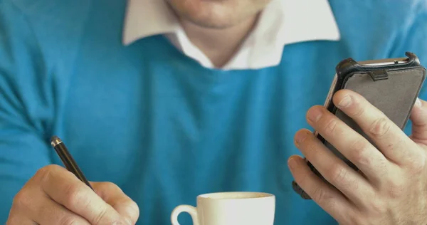 Erwachsener Mann benutzt Smartphone und trinkt Kaffee — Stockfoto