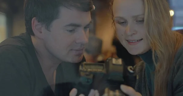 Young couple with camera choosing the best shots — Stock Photo, Image