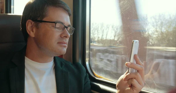 Young man video chatting on cell in train — Stock Photo, Image