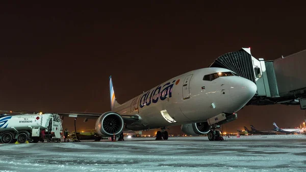 Včasný nástup do letadla FlyDubai a nakládka zavazadel v zimní noci — Stock fotografie