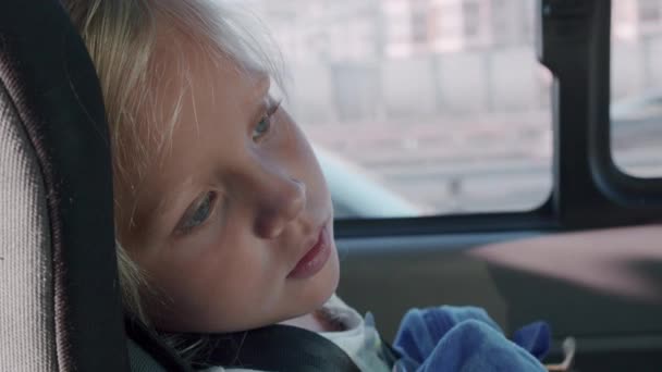 Tired little girl in car safety seat — Stock Video