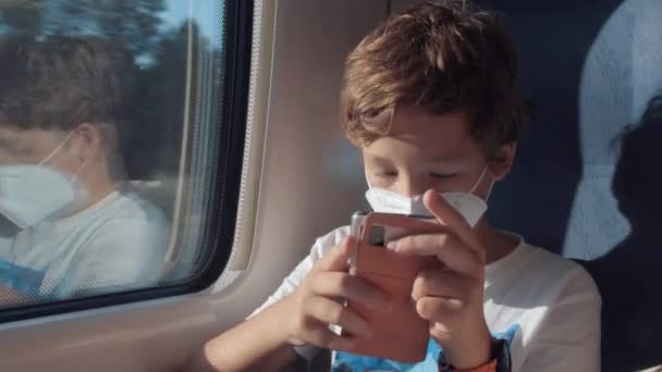 Niño llenando el tiempo de viaje jugando juegos móviles — Vídeo de stock