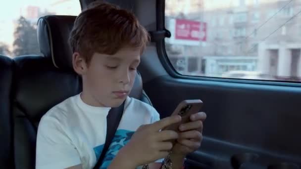 Αγόρι ξοδεύει χρόνο με το κινητό κατά τη διάρκεια του αυτοκινήτου — Αρχείο Βίντεο
