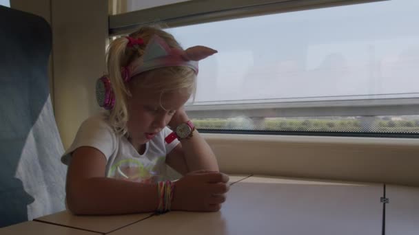 Petit voyageur regardant des dessins animés au téléphone dans le train — Video