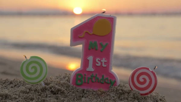 One year old birthday candle on the beach — Stock Photo, Image