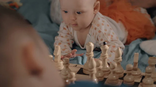 Baby girl is curious about chess — Stock Photo, Image