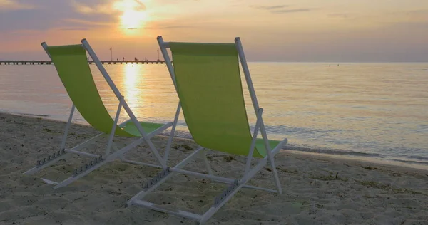 Chaise longues vid havet i solnedgången — Stockfoto