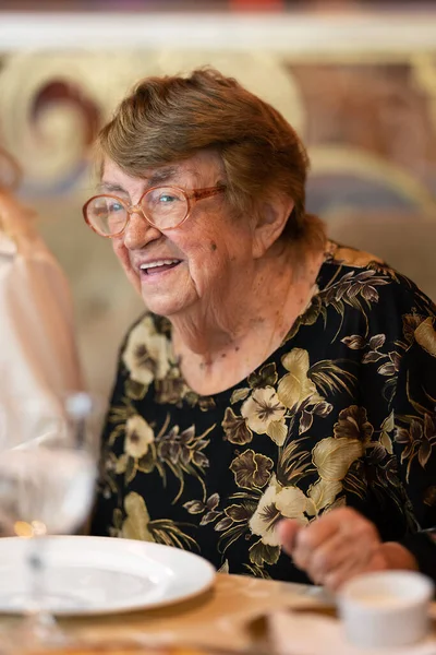 Счастливая пожилая женщина за семейным ужином — стоковое фото