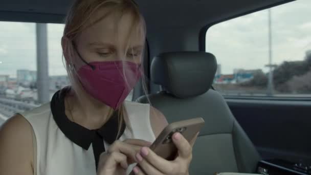Passageiro táxi fêmea na rede de surf máscara no celular — Vídeo de Stock