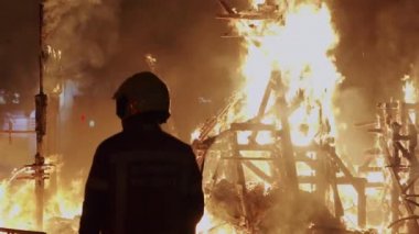 İtfaiyeci, İspanya 'daki Las Fallas festivalinin şenlik ateşini kontrol ediyor.