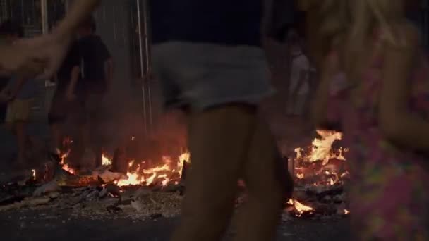 Las Fallas e suas fogueiras. Crianças andando em círculo pela escultura em chamas — Vídeo de Stock