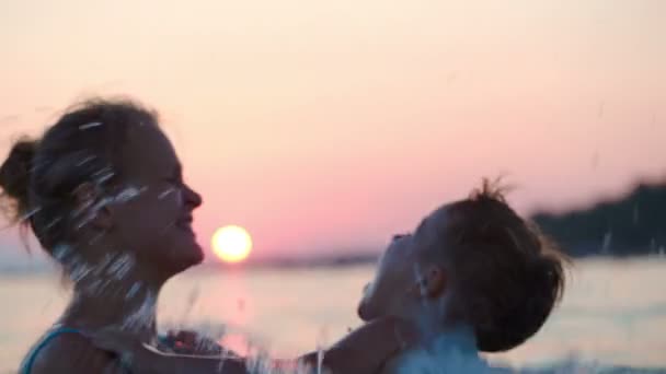 Matka i syn w morze o zachodzie słońca — Wideo stockowe