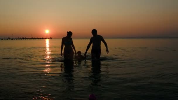 Familie kommt bei Sonnenuntergang aus dem Meer — Stockvideo