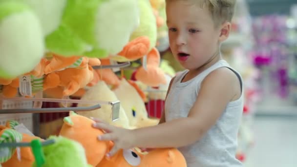 Junge wählt Spielzeug im Geschäft — Stockvideo