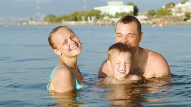 Pais felizes e filho tomando banho no mar no resort — Vídeo de Stock