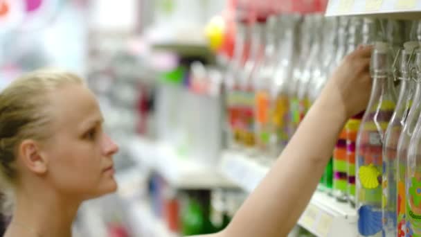 Mujer eligiendo botella decorativa — Vídeos de Stock