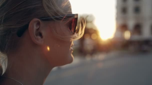 Mujer con gafas de sol mirando a la distancia — Vídeos de Stock