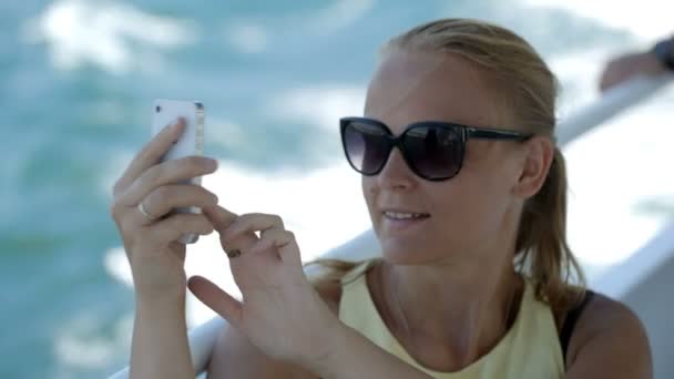 Frau macht Selfie mit Handy auf dem Boot — Stockvideo