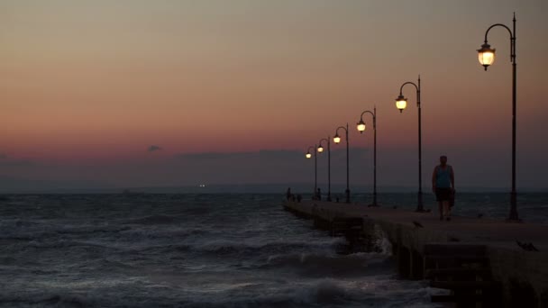 Gente caminando y pisando el muelle por la noche — Vídeos de Stock