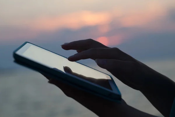 Woman hands typing on pad outdoor at sunset — Stock Photo, Image