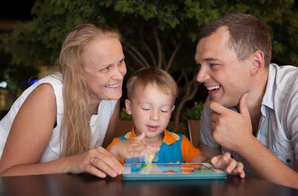Happy family with tablet PC outdoor in the evening — Stock Photo, Image