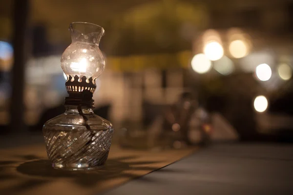 Антикварна олійна лампа з тьмяним світлом на столі в кафе — стокове фото