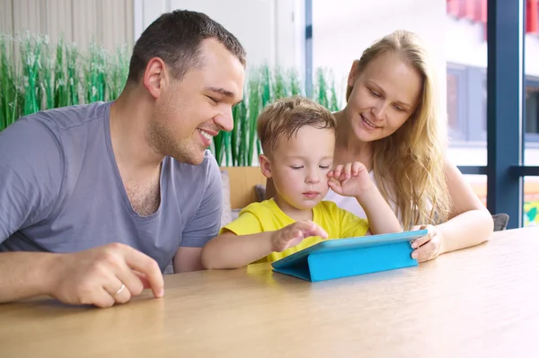 Glad familj på tre med tablet PC i café — Stockfoto