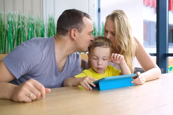 Rodziców całując syn gra na podkładce — Zdjęcie stockowe
