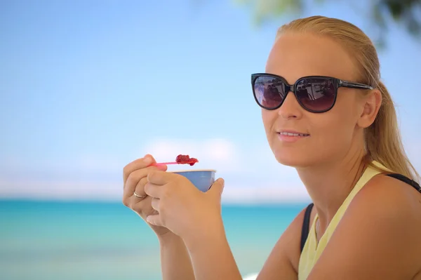 Young woman eating ice-cream on the beach — Stock Photo, Image