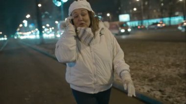 Şehirde akşam yürüyüş sırasında telefon heyecan verici olan kadın konuşmak